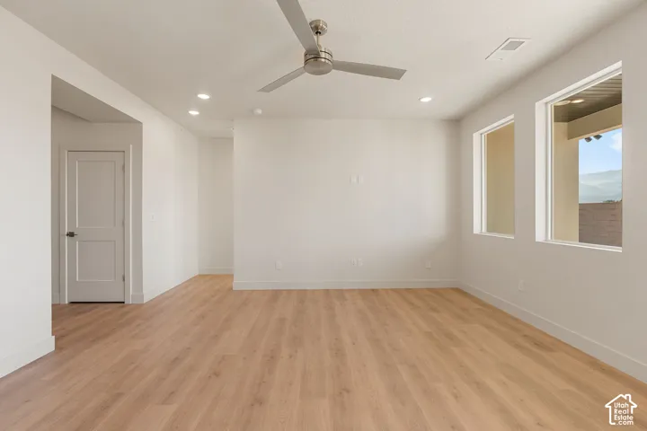 Interior space featuring wood-finish flooring, recessed lighting, a modern ceiling fan, and large windows