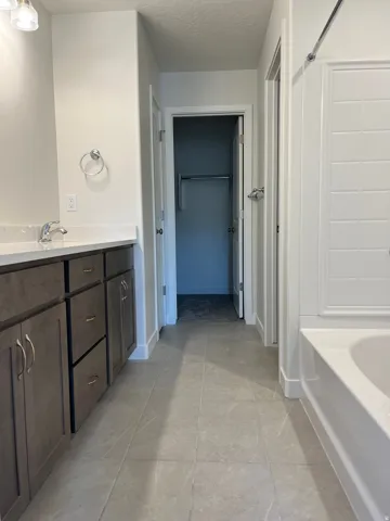 Bathroom featuring a vanity with dark wood-finish cabinetry, a white countertop, and a chrome faucet