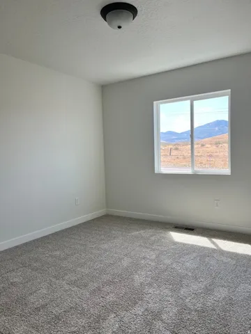 Carpeted room with a double-pane window offering mountain scenery