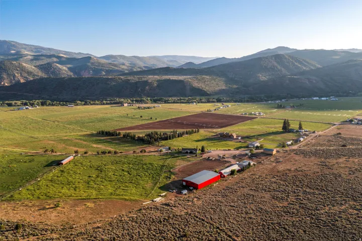 Expansive agricultural land with a large red barn, multiple outbuildings, and cultivated fields