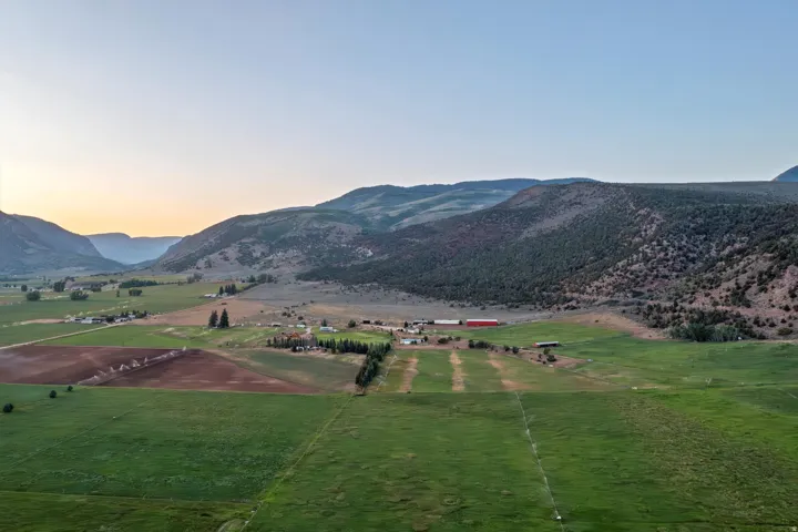 Expansive rural landscape featuring a valley with mountainous terrain