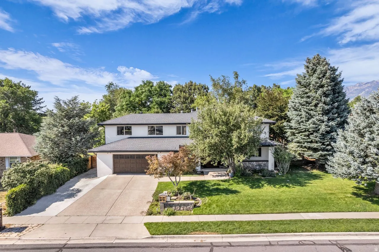Two story home featuring a two-car garage with a wood-finish door