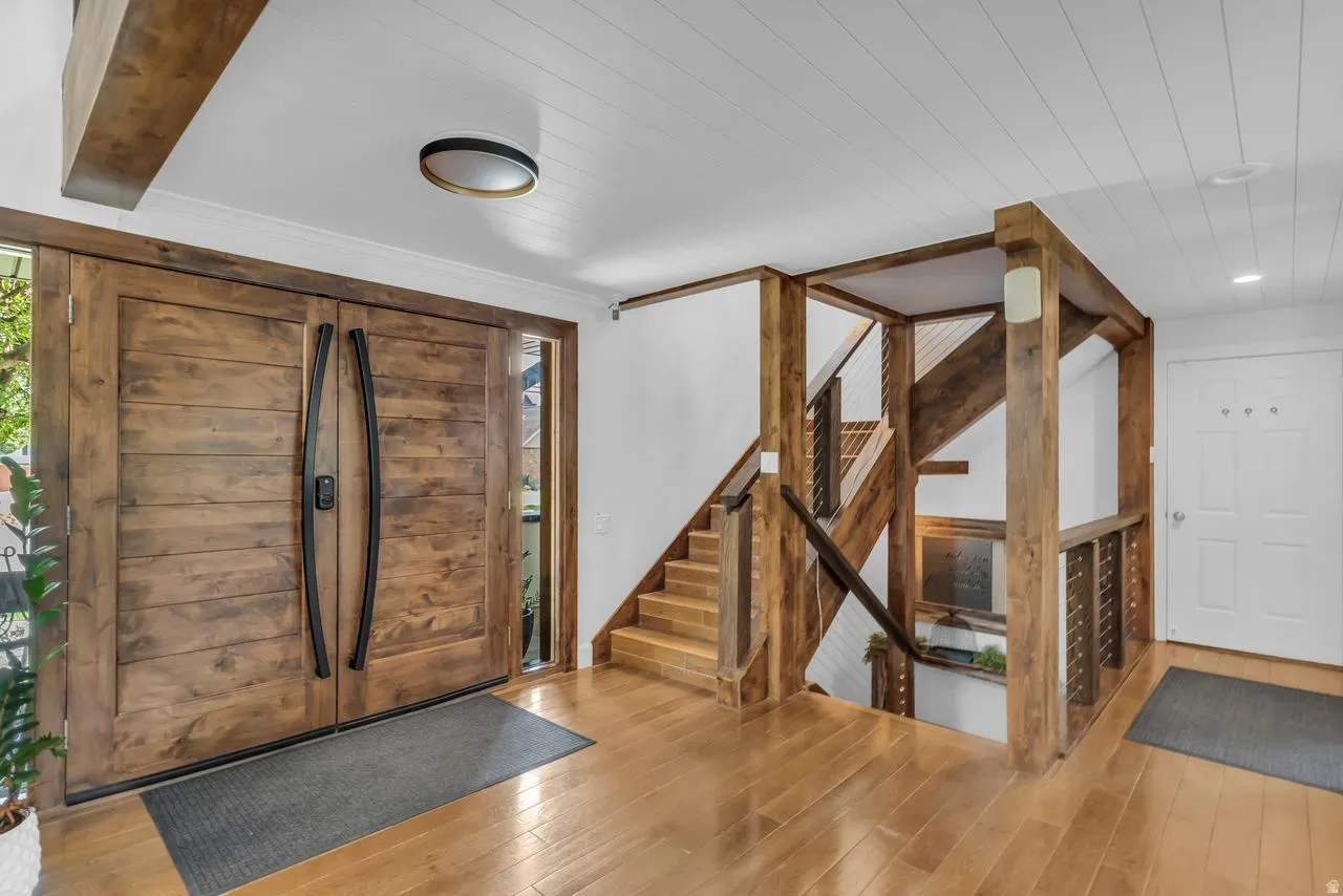Grand entrance featuring double entry custom doors flanked by sidelight windows and a modern staircase