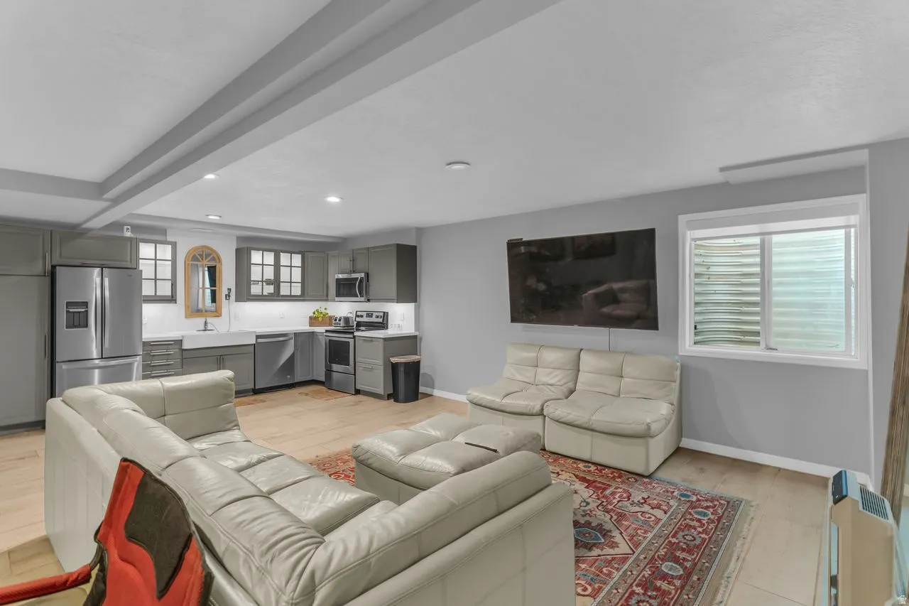 Open-concept living area featuring wood-finish flooring, recessed lighting, and window