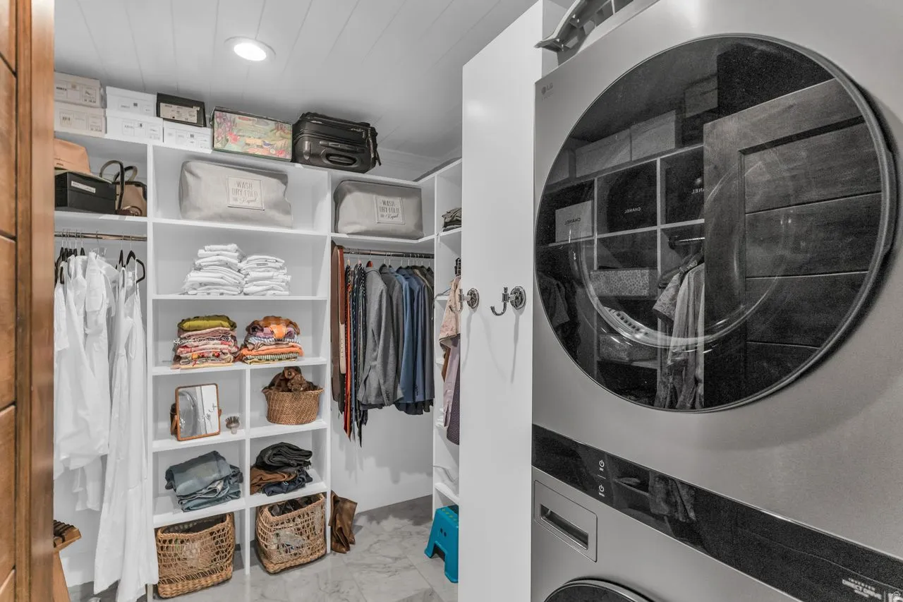 Custom closet system featuring extensive shelving and washer/dryer