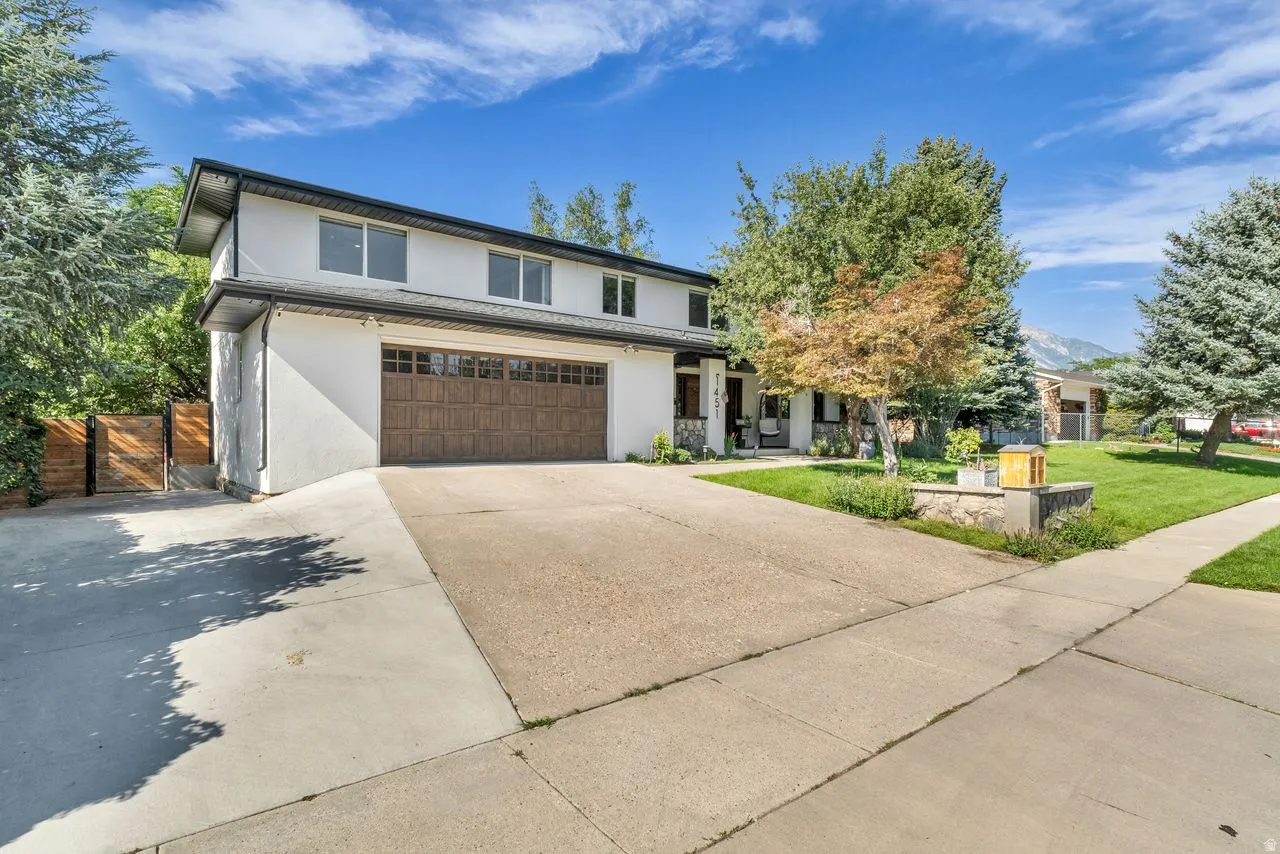 Concrete driveway leading to an attached two-car garage with new wood garage door