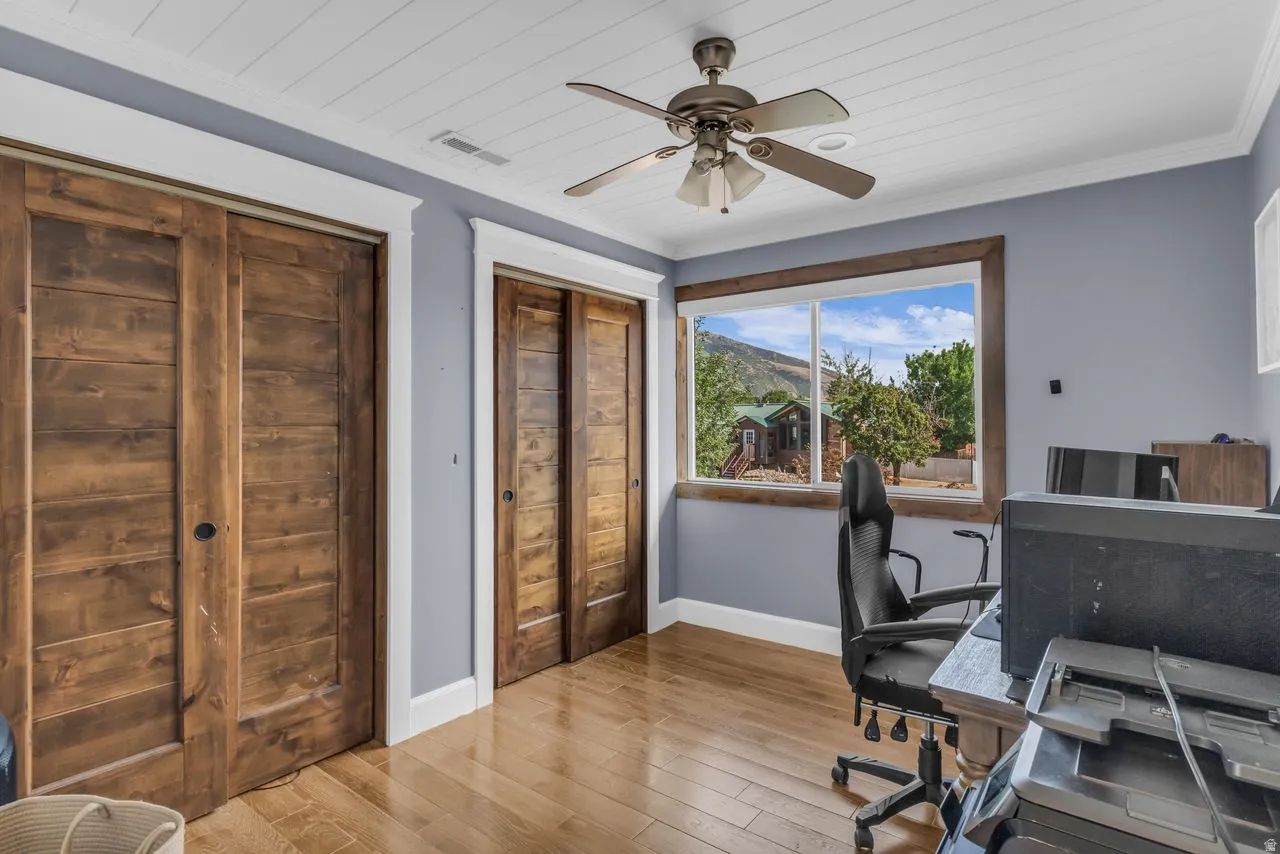 Bright room featuring custom wood closet doors and a window with wood framing overlooking natural scenery