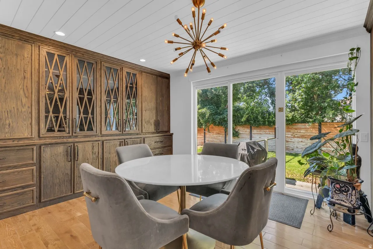 Additional dining area with custom oak and glass built-in storage and sliding glass door to the backyard