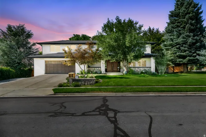 Contemporary residence featuring a white stucco exterior, black roofline, and stone accents