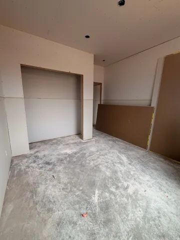 Interior space under construction featuring framed walls, an open doorway, and a concrete subfloor