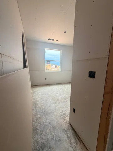 Room under construction featuring an untextured ceiling, a single window, and visible drywall