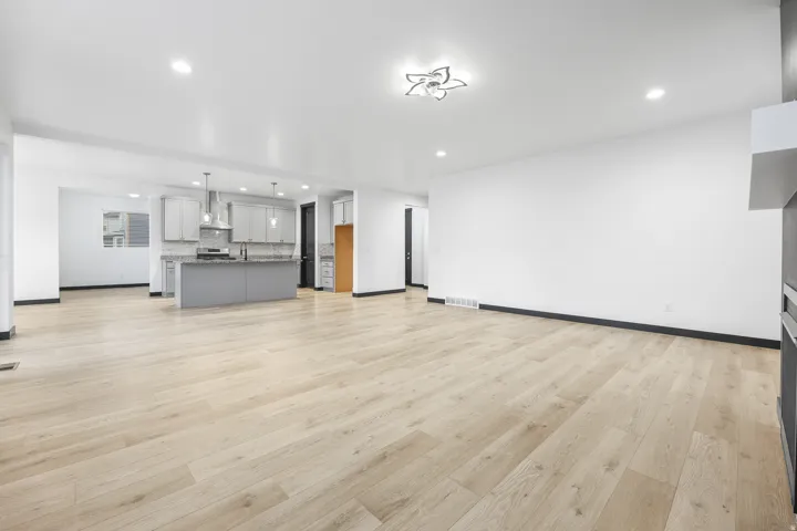 Open-concept living space featuring wood-finish flooring, recessed lighting, and a contemporary ceiling fixture