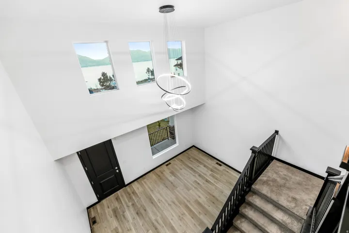Two-story entryway with high ceilings and wood-finish flooring