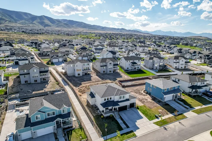 Spacious residential community featuring a variety of architectural styles, paved streets, and mountain backdrops