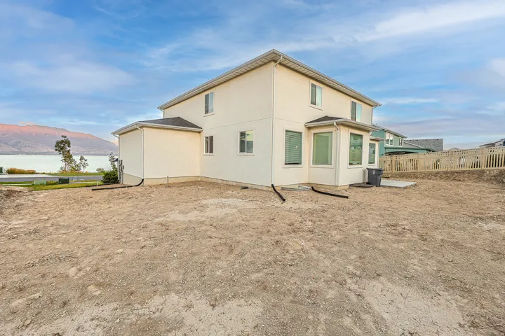 Rear exterior featuring a neutral stucco finish and bay windows