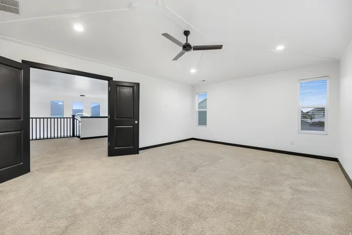 Spacious room with vaulted ceilings and recessed lighting