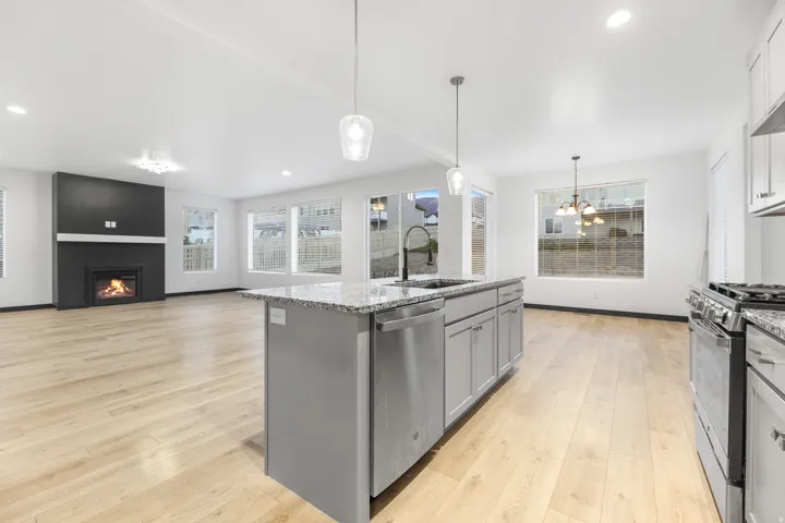 Open-concept living area featuring a kitchen island with pendant lighting and a built-in dishwasher