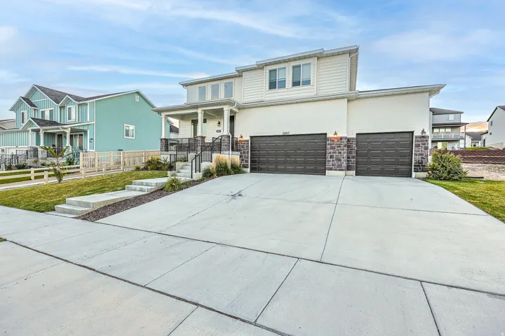 Contemporary two-story residence featuring a combination of stucco and siding, with a covered front porch and a wide concrete driveway