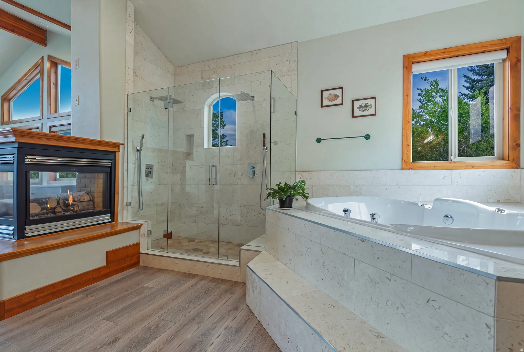 Freestanding soaking tub with tiled surround, adjacent to a glass-enclosed shower featuring a tiled interior and built-in niche