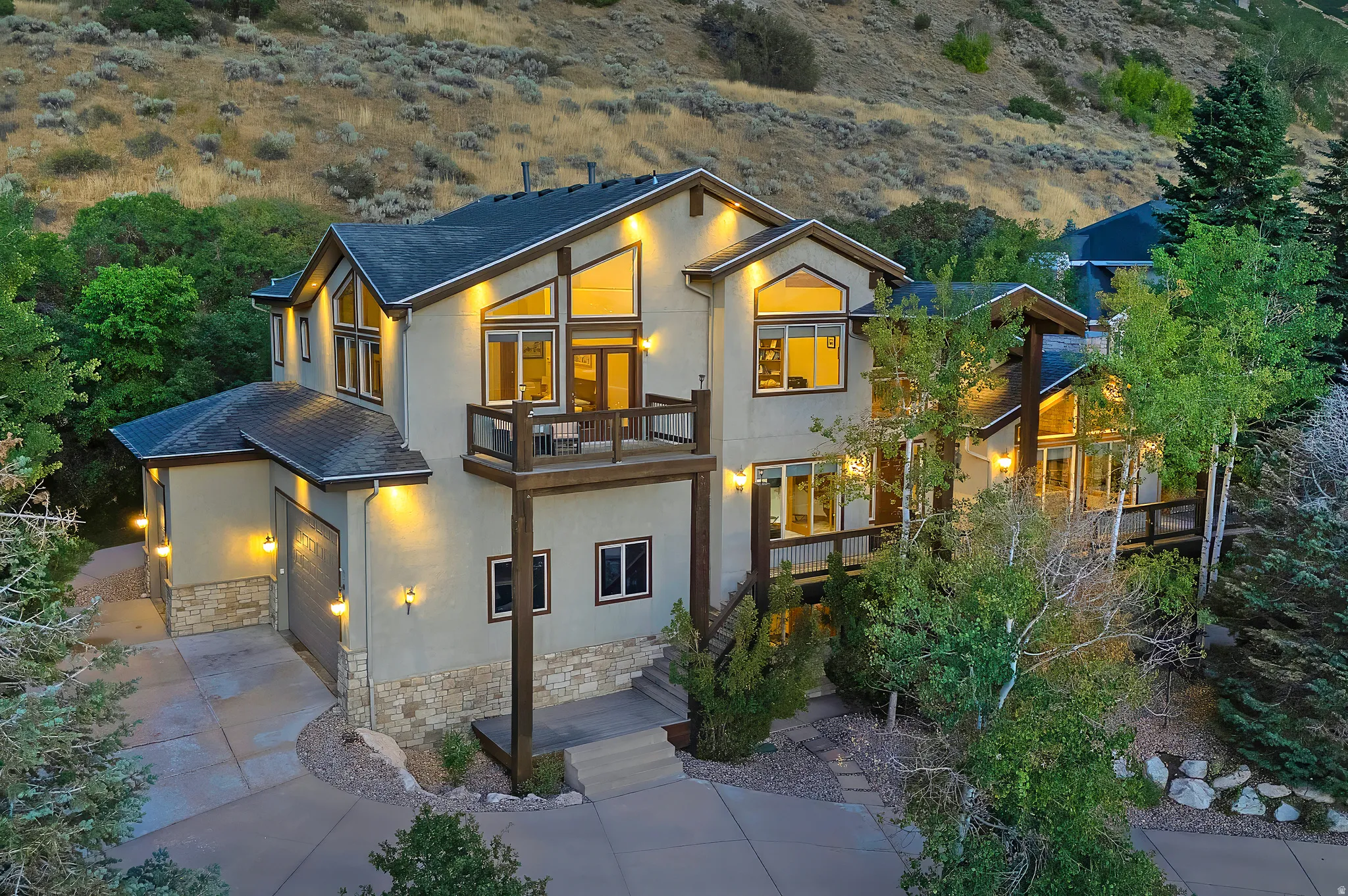 Multi-level residence featuring contemporary architectural styling, extensive window placements, and a stucco exterior with stone accents