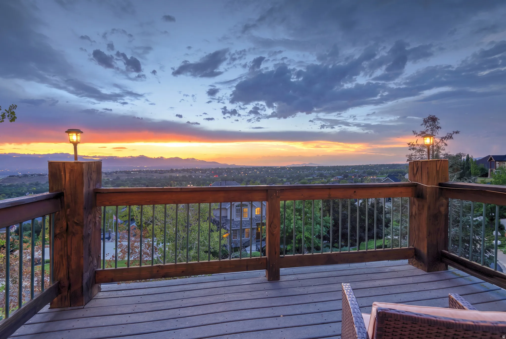 Outdoor deck with a wide horizon, wood-finish decking, and robust wooden railings with dark metal balusters