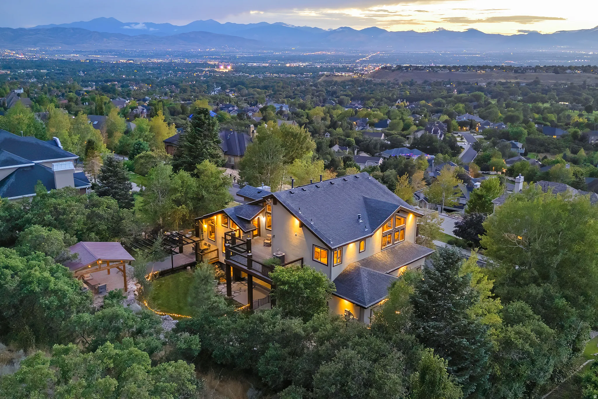 Contemporary residence with multiple outdoor decks and a gazebo, surrounded by mature trees