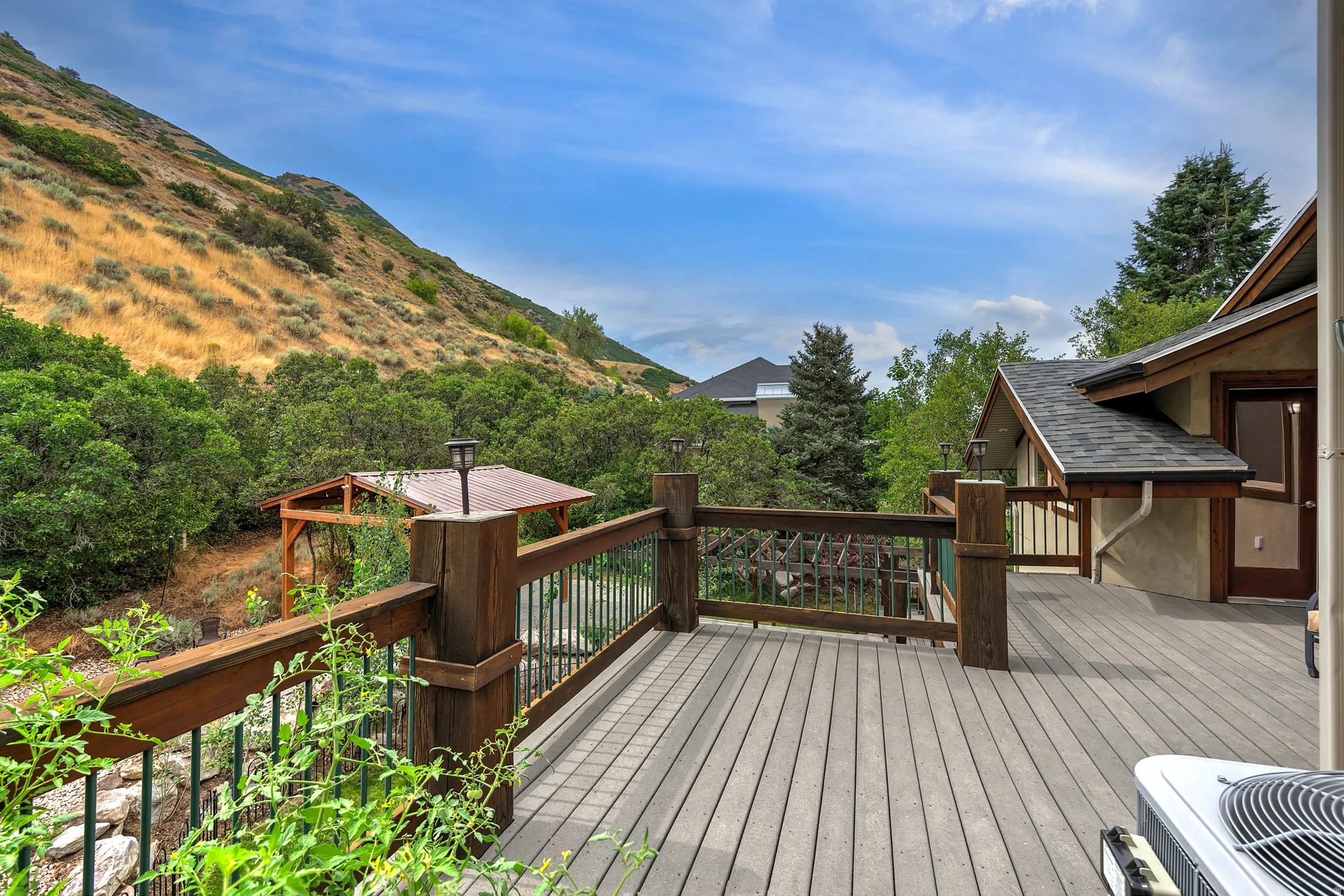 Expansive outdoor deck featuring wood-finish decking and a robust wood railing with metal balusters