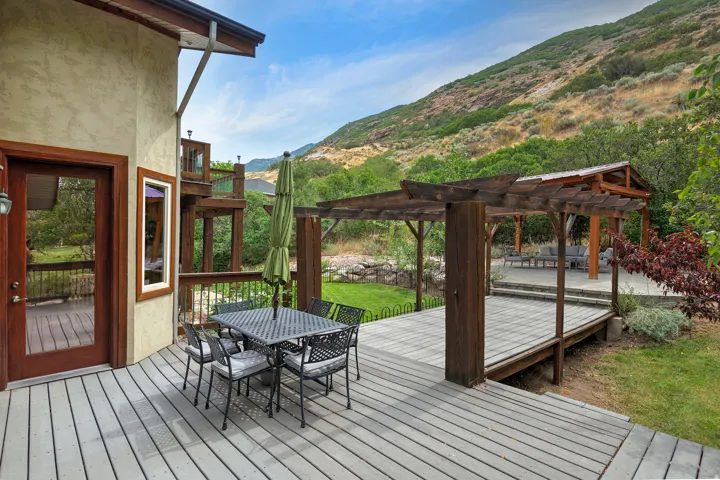 Expansive outdoor decking featuring a pergola, built-in gazebo, and mountain backdrop