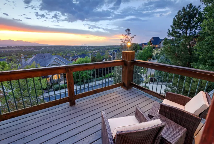 Deck featuring composite decking, wood railing with metal balusters, and an integrated post light