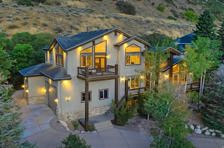 Multi-level residence featuring contemporary architectural styling, extensive window placements, and a stucco exterior with stone accents