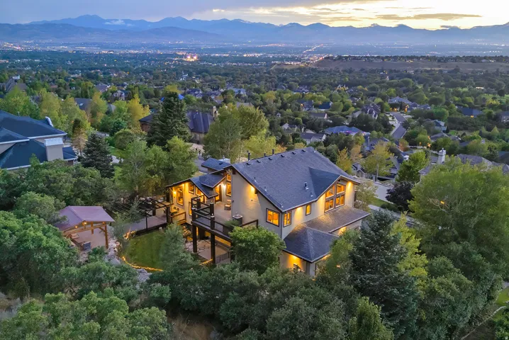 Contemporary residence with multiple outdoor decks and a gazebo, surrounded by mature trees