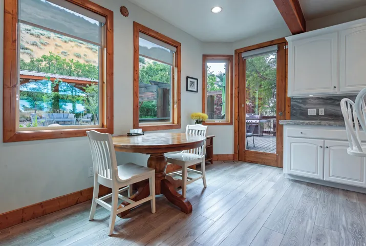 Light wood-finish flooring complements the white cabinetry and dark stone countertops