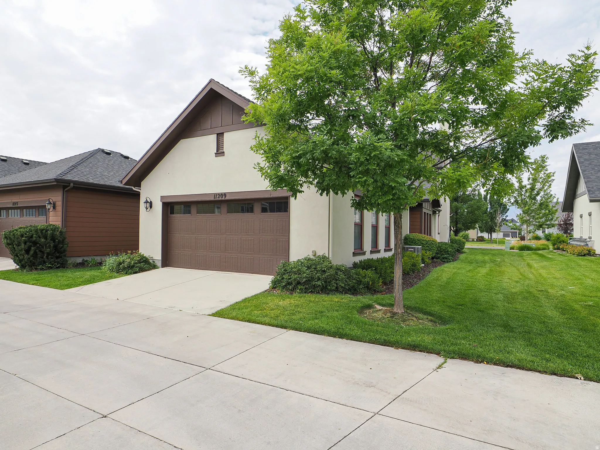 Stucco exterior with a peaked roofline and dark trim accents
