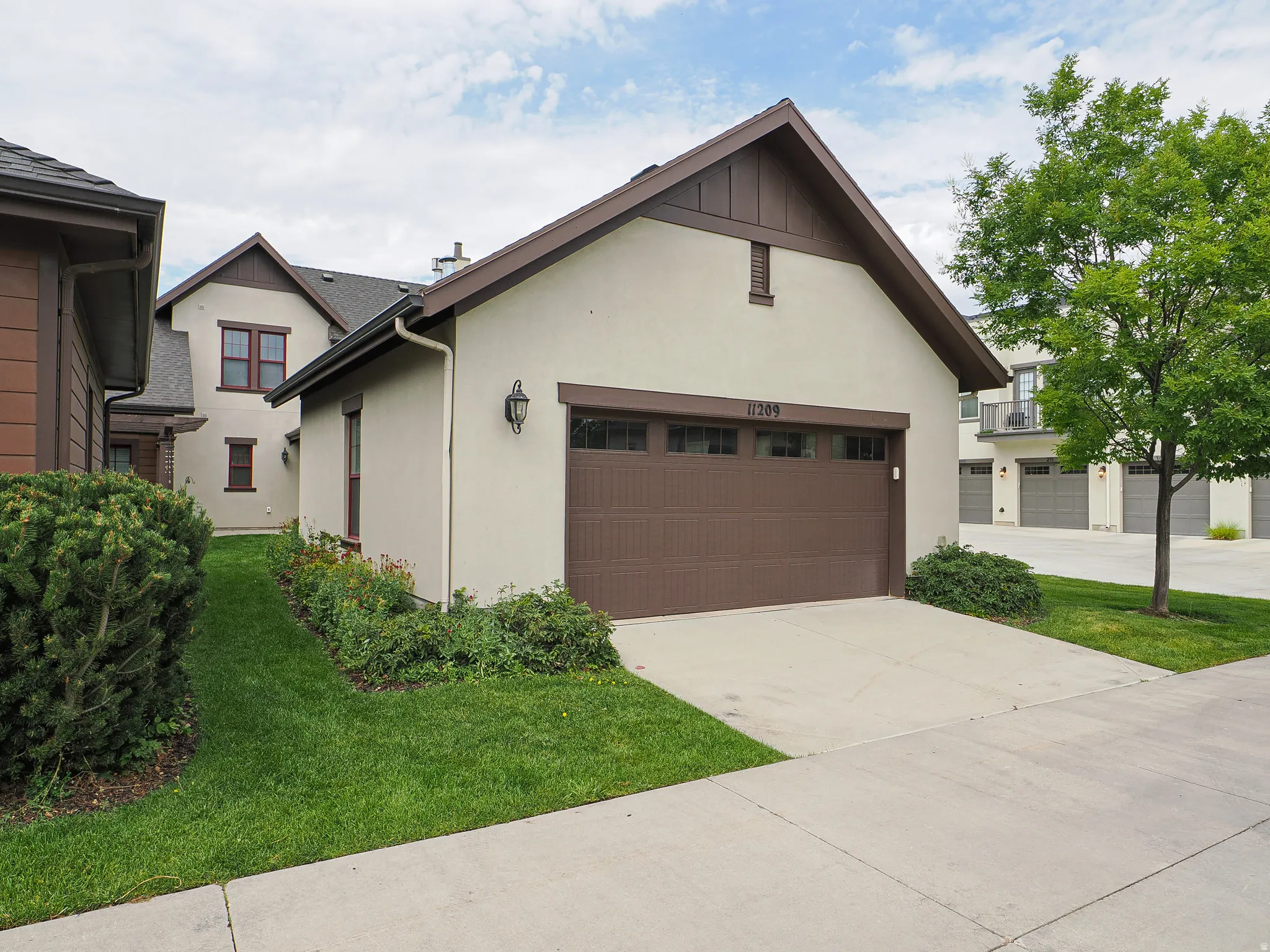 Detached two-car garage with a brown panel door and window accents