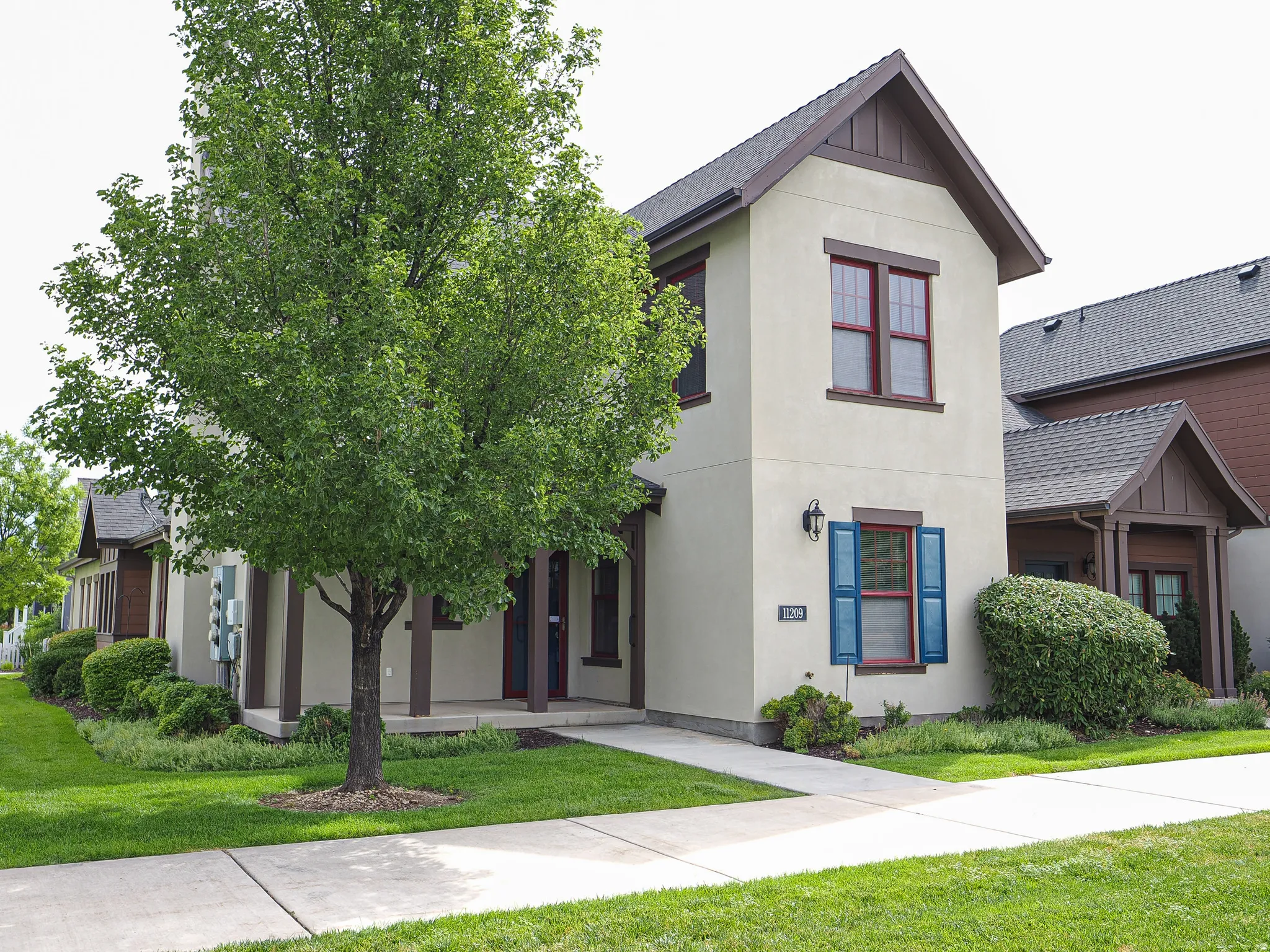 Stucco exterior with gabled roofline and brown trim accents