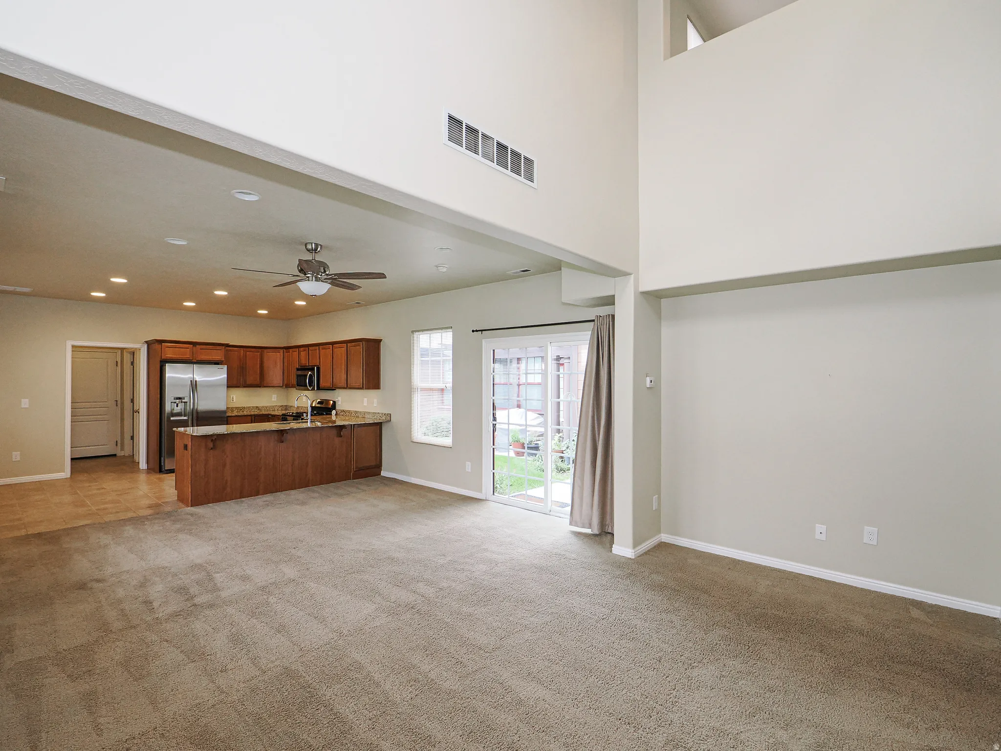 Open concept living area featuring a vaulted ceiling and direct outdoor access
