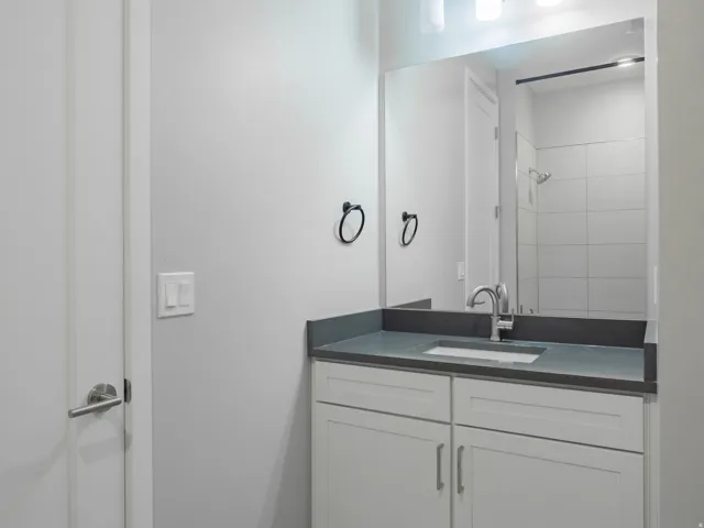 Bathroom vanity featuring a light gray countertop with an integrated rectangular sink