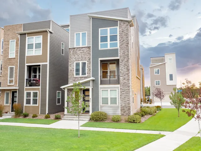 Modern multi-story facade featuring varied siding materials and stone accents