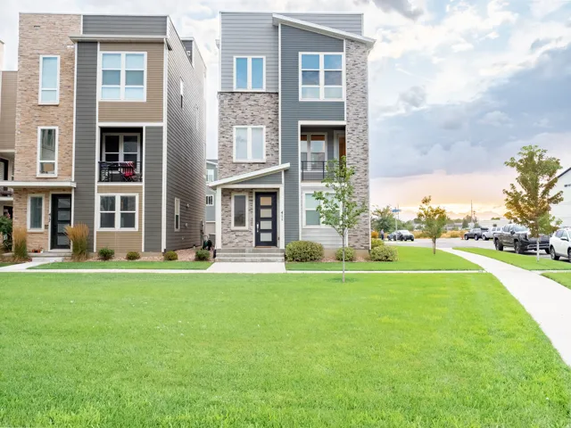 Contemporary multi-story exterior featuring a varied material facade of stone, siding, and paneling