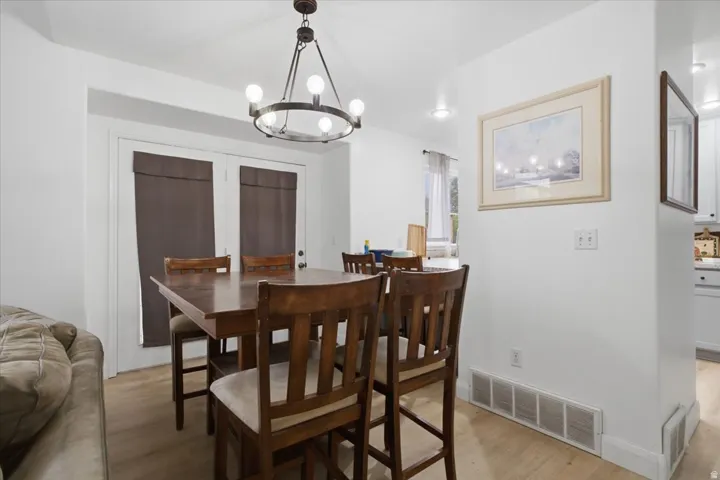 Dining area featuring light wood-finish flooring and a bronze-finish chandelier