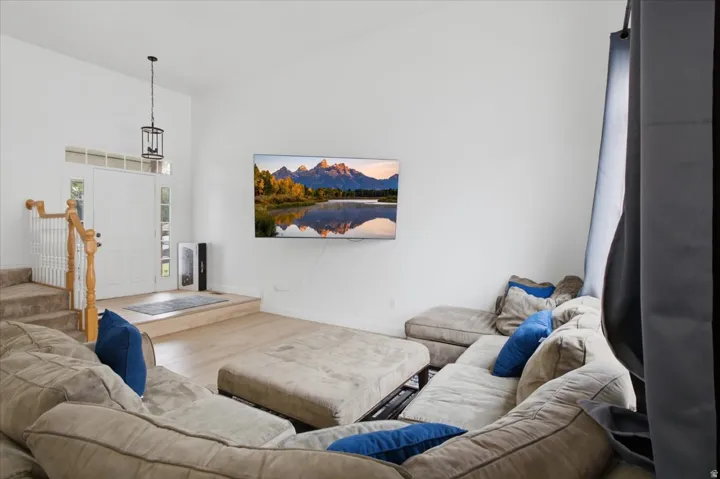Vaulted ceilings enhance this living area featuring wood-finish flooring and a staircase with wood newel posts and handrail