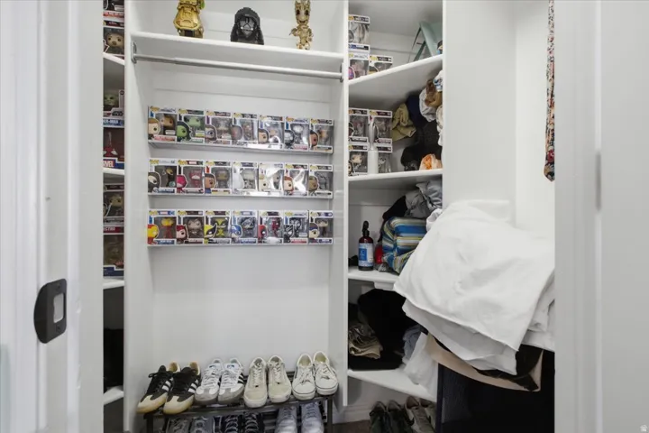 Built-in closet system featuring white shelving, a full-width hanging rod, and integrated shoe storage
