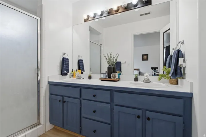 Dual vanity with blue cabinetry and white countertops