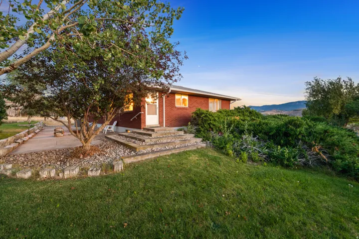 Brick exterior ranch-style residence featuring a white storm door entry
