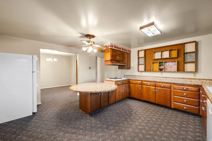 Kitchen featuring wood-finish cabinetry, granite-style countertops, and a built-in range