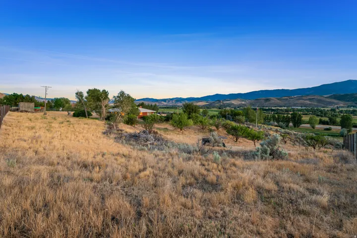 Expansive land parcel with natural vegetation and distant mountain ranges