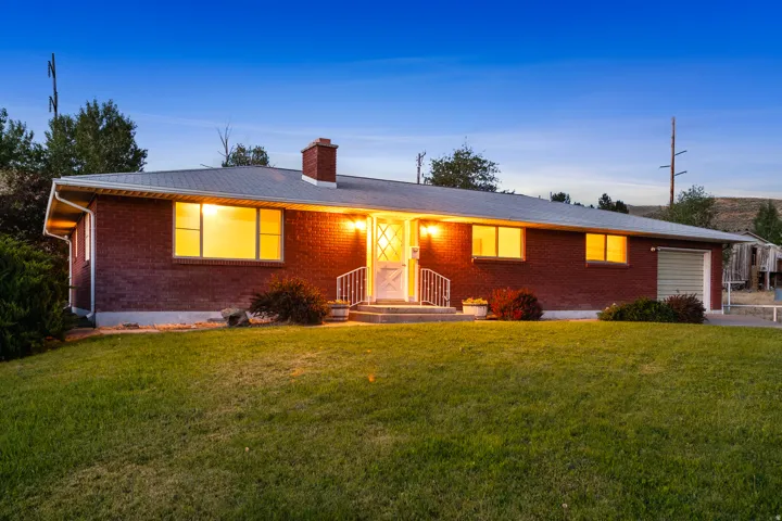 Brick exterior ranch-style home featuring a prominent front entrance with a white storm door and railing