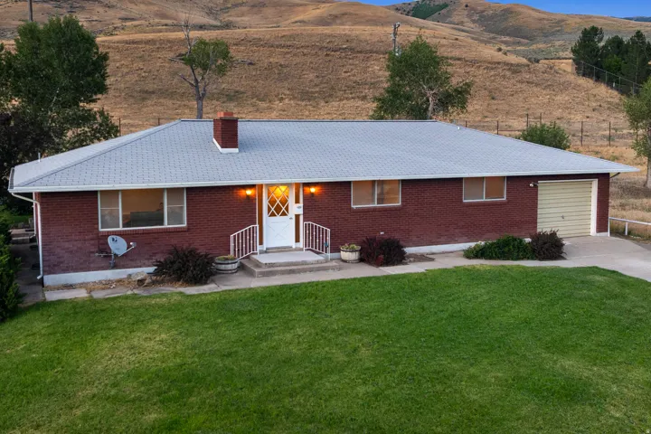 Brick exterior featuring a metal roof and a spacious front lawn