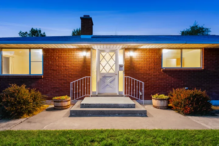 Brick exterior with a white entry door featuring decorative glass panels