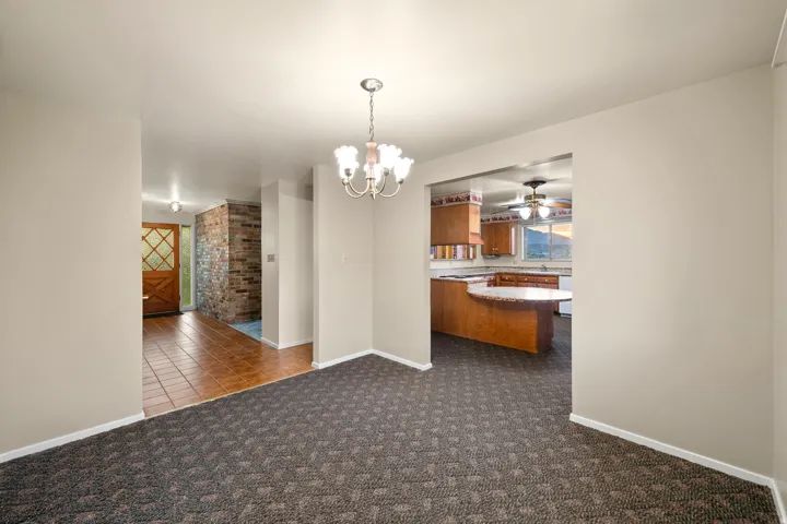 Living area featuring patterned carpeting and a chandelier